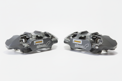 Grey Alcon brake calipers on bright white background