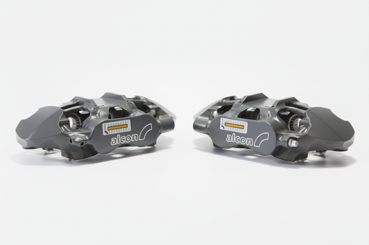 Grey Alcon brake calipers on bright white background