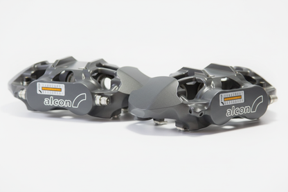Pair of grey Alcon brake calipers with spec label